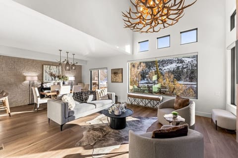 Sophisticated, open floor plan living area with fireplace, smart TV, and vaulted ceilings