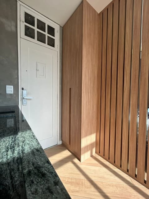 Floor to ceiling closet for storage, wood partition to separate the bedroom from kitchen.