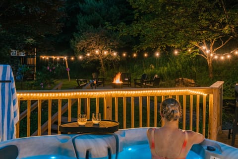 Soak your cares away in the hot tub as you watch the firepit glow under twinkling lights