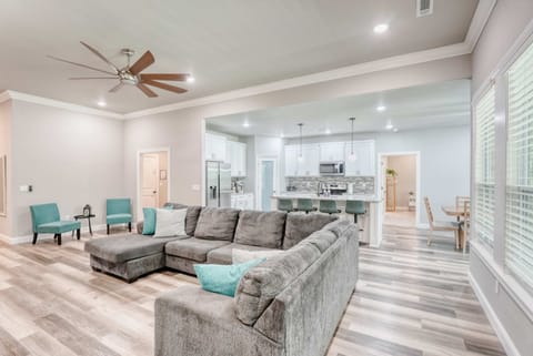 Stylish living area featuring a warm fireplace, spacious sectional seating, and plenty of natural light pouring in through the windows.