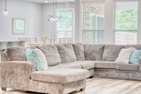 Sunlight streams through expansive windows, illuminating a meticulously crafted living room. A place to relax and connect.