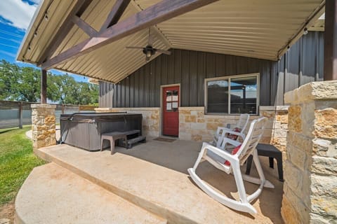 Relax and recharge in the expansive backyard, featuring a private hot tub, outdoor dining area, and plenty of space to unwind under the Texas sky. 