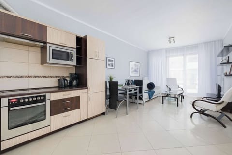 Functional kitchenette with bright furniture and built-in appliances.