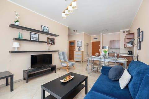 Close-up of a light leather sofa with decorative cushions. A coffee table stands in front of the sofa.