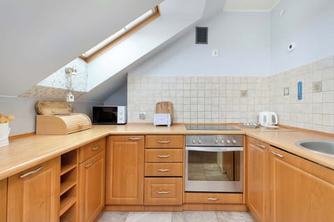 Wooden cabinetry and a spacious countertop offer a home-like cooking experience.

