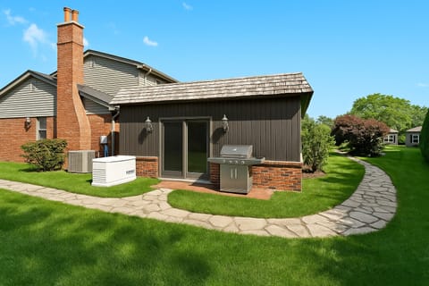 Side view of the home featuring the grill area and garden pathway.