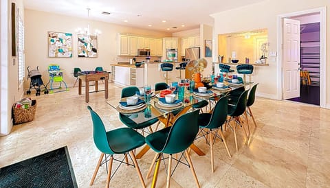 Bright open dining and kitchen area with seating for 10, sleek breakfast bar, and a fully stocked kitchen. Family-friendly touches include a foosball table, high chair, and stroller—perfect for shared meals and fun. #VacationRental #FamilyFriendly