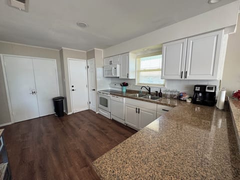 Another view of kitchen, with pantry and full size refrigerator.