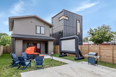 Backyard with movie theater, adirondack chairs, and bbq grill