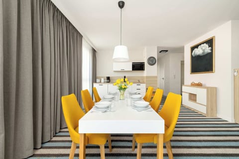 A modern dining room with a large table, comfortable chairs and stylish lighting. The space is bright and airy, perfect for family dinners.