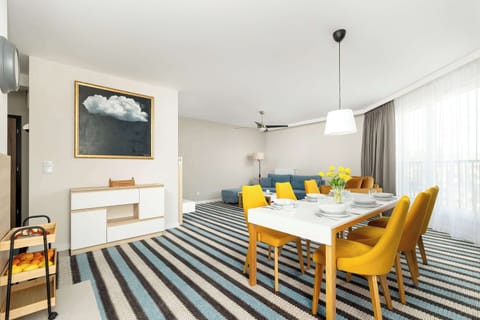 An elegant dining room with a large table, comfortable chairs and modern lighting, it is a good place for long conversations over food.