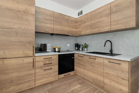 A fully equipped kitchen with wooden cabinetry offers everything you need for convenient cooking.