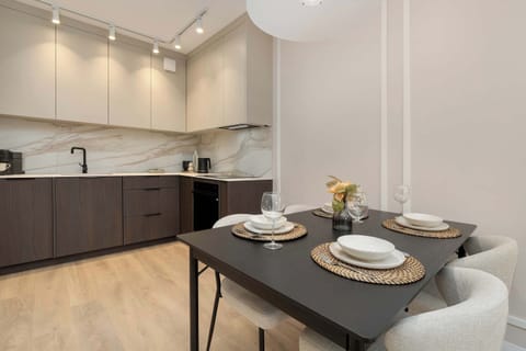 A modern kitchen with matte black cabinets and under-cabinet lighting. The layout is compact, practical, and stylish.