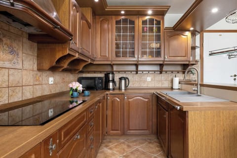 A kitchen with wooden cabinetry and modern appliances. Traditional and functional design.