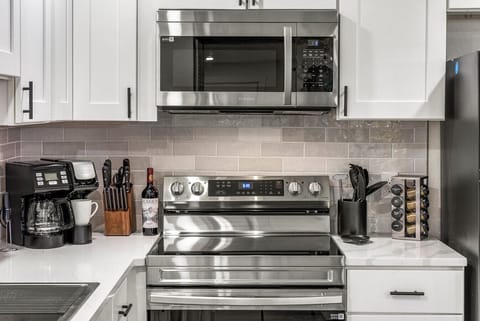 Chef‑ready kitchen with quartz counters, stainless steel appliances & breakfast bar