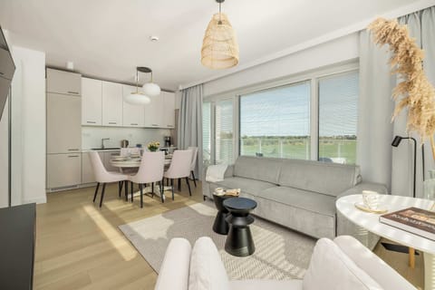 A larger open-concept living room and dining space, blending contemporary furniture with warm tones and décor.