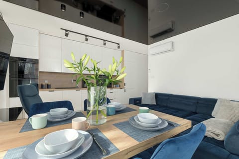 A table set with elegant dinnerware and fresh flowers invites shared meals in a warm setting.