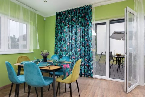 A bright dining area with floor-to-ceiling windows and vibrant furniture for a cheerful ambiance.