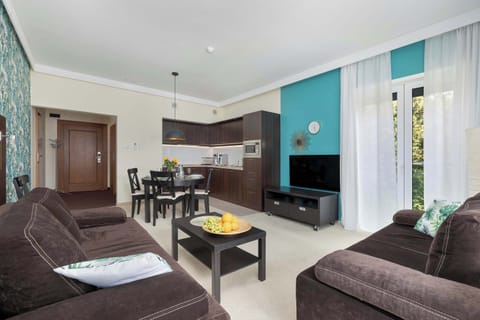 A bright living area with a sofa, dining table, and glass doors to a balcony. A spacious setting for leisure and comfort.