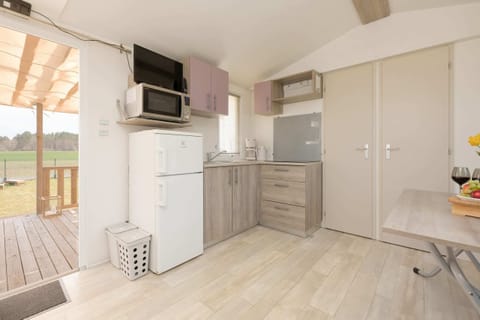 A practical and well-equipped kitchen featuring light wood and neutral tones with all necessary appliances.