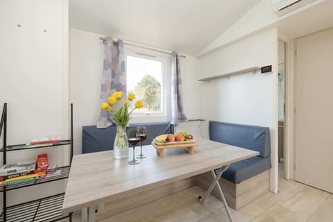 The combined space showcasing a dining table and kitchen facilities, designed to maximize functionality in the mobile home.