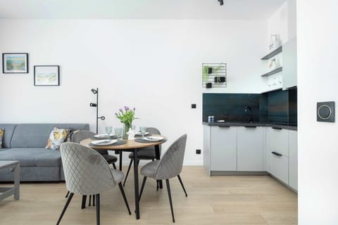 A stylish dining room with a round table for four, decorated with modern decorations, creating a pleasant atmosphere for meals.