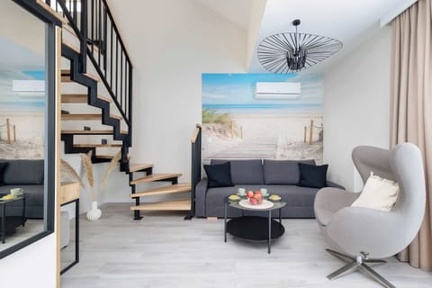 Living room with air-conditioning, gray sofa, coffee table, armchair and television.