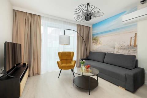 A bright living room with a large window and a comfy armchair offers the perfect spot for morning coffee and evening relaxation.