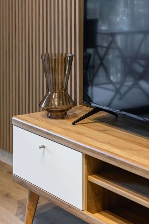 A close-up of the shelf with a TV and a decorative vase.


