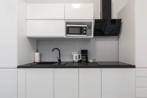 A compact yet functional kitchen with all necessary appliances, blending style and practicality.
