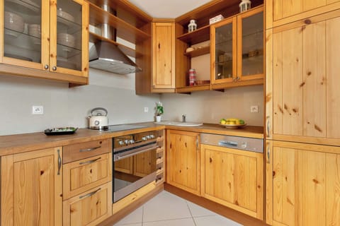 A fully equipped kitchen featuring wooden cabinets, a modern countertop, and essential appliances for easy meal preparation.