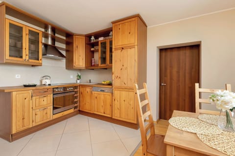 A fully equipped kitchen featuring wooden cabinets, a modern countertop, and essential appliances for easy meal preparation.