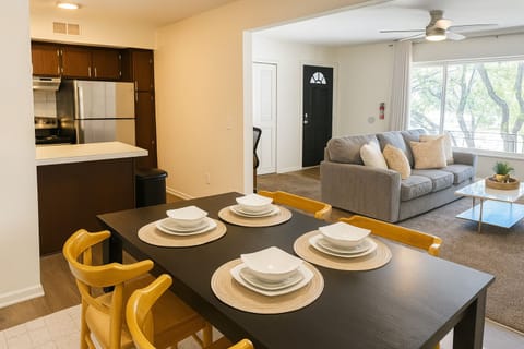 Dining area with seating for four, flowing into the open living and kitchen space.