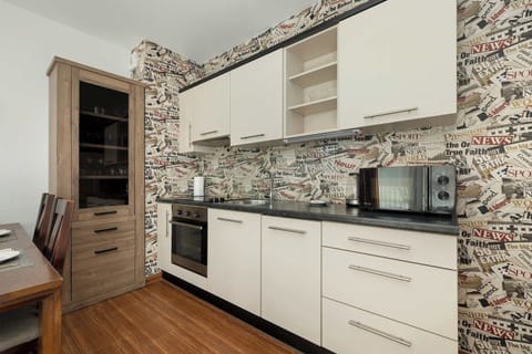 A modern kitchen with patterned backsplash tiles, sleek cabinetry, and built-in appliances.

