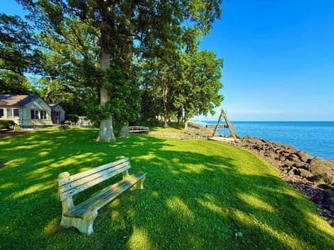 Enjoy coffee or cocktails under the shade of towering trees with direct lake views and plenty of room to relax on this private patio.
