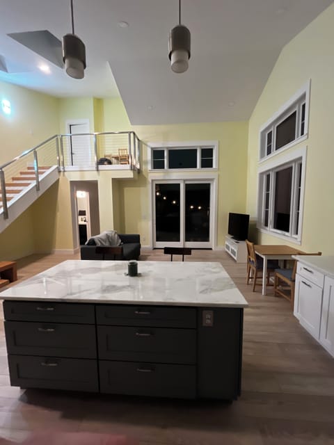 Kitchen island and living room with glass door out onto private deck. 