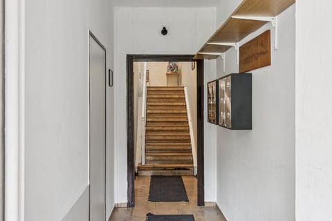 Eingangsbereich mit Treppe, Keyboxen an der Wand, Regalbrettern und Läufern – übersichtlicher Zugang zur Ferienunterkunft.