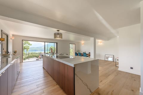 Modern and fully equipped kitchen, featuring a large marble central island with an additional dining area for 4 people