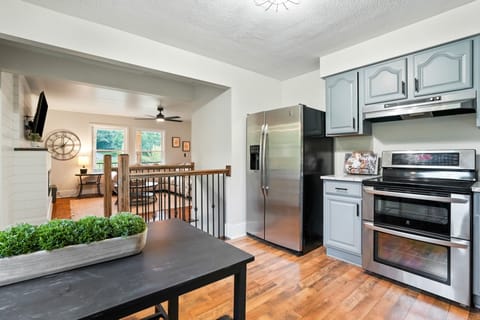 Enjoy a bright, fully equipped kitchen with stainless steel appliances, spacious counters, and gray cabinetry. The open layout flows into a cozy living room—perfect for gathering, relaxing, and sharing meals after a day of adventure.
