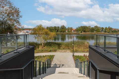 A picturesque lake view from a terrace, with outdoor seating and serene surroundings.
