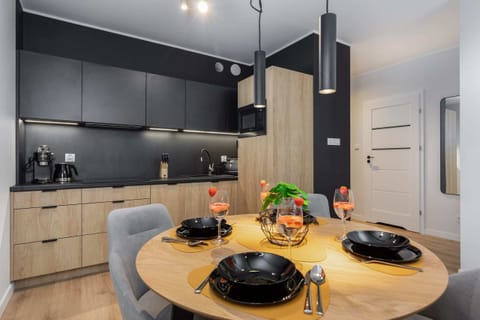 A dining area and open-plan kitchen, featuring a mix of modern and rustic design elements.
