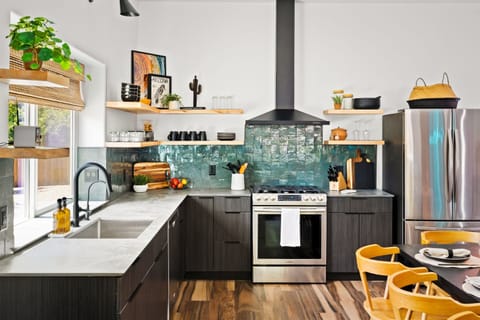 Modern kitchen with stainless steel appliances, open shelving, and a sleek design for cooking and entertaining.