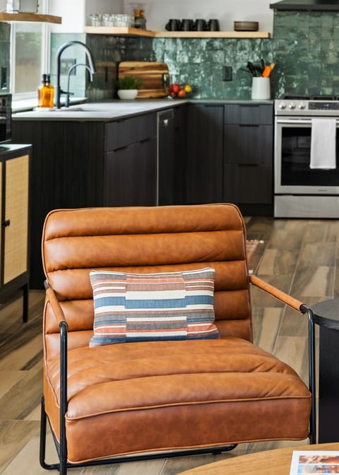 Cozy corner with a comfy chair, stylish kitchen, and inviting atmosphere.
