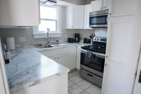 The kitchen is stocked with all the essentials—fridge, stove, oven, microwave, dishwasher, coffee maker, and blender. Whether you're making a full meal or just a quick cup of coffee, you’ll have everything you need.