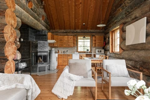 Gather around the stunning stone fireplace in the heart of the cabin, which connects the rustic log living space with the full, well-equipped kitchen and dining area.