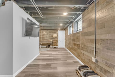 Basement with fitness equipment and open space   - Mounted TV and seating for entertainment nights   - Wide layout perfect for exercise or relaxation