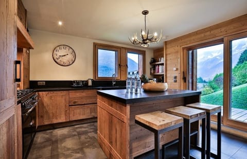 Kitchen area, with a terrasse outside with a wooden table and incredible views
