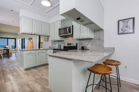 Kitchen with modern open design, stainless appliances and a cozy breakfast bar, perfect for morning coffee
