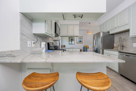 Kitchen featuring sleek stainless appliances and elegant marble countertops, perfect for culinary adventures