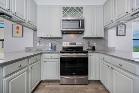 Bright and inviting kitchen featuring stainless appliances and elegant light blue cabinetry, perfect for culinary adventures